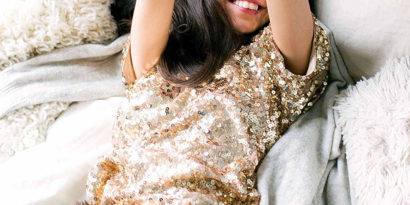 woman-wearing-brown-sequin-dress-laying-on-the-bed-698864